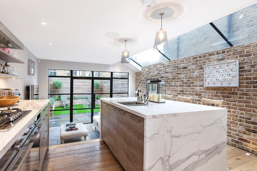 Design ideas for a contemporary open plan kitchen in London with a double-bowl sink, marble benchtops, light hardwood floors, with island, beige floor and open cabinets.