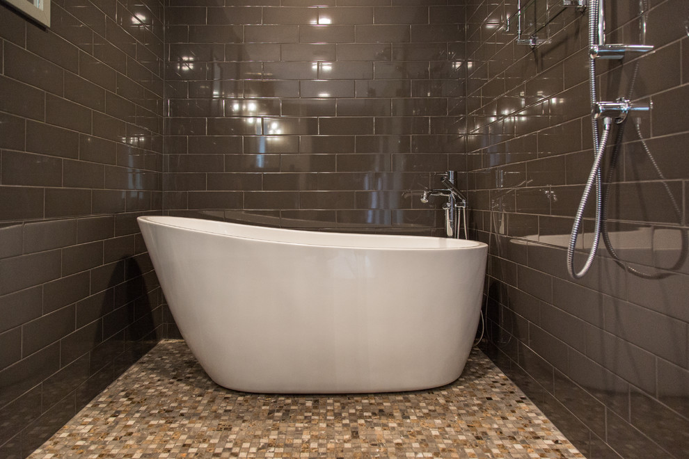 Design ideas for a large transitional master wet room bathroom in Boston with shaker cabinets, medium wood cabinets, a freestanding tub, a one-piece toilet, gray tile, ceramic tile, brown walls, ceramic floors, an undermount sink, solid surface benchtops, white floor and a hinged shower door.