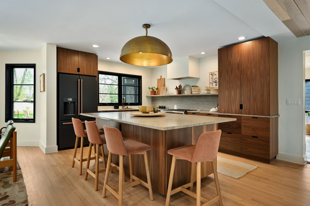 Inspiration for a contemporary medium tone wood floor and brown floor open concept kitchen remodel in Kansas City with an undermount sink, flat-panel cabinets, medium tone wood cabinets, gray backsplash, black appliances, an island and gray countertops