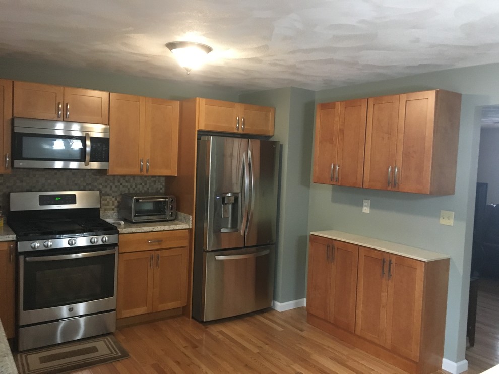 Small transitional u-shaped medium tone wood floor eat-in kitchen photo in Providence with shaker cabinets, medium tone wood cabinets, laminate countertops, stainless steel appliances and no island