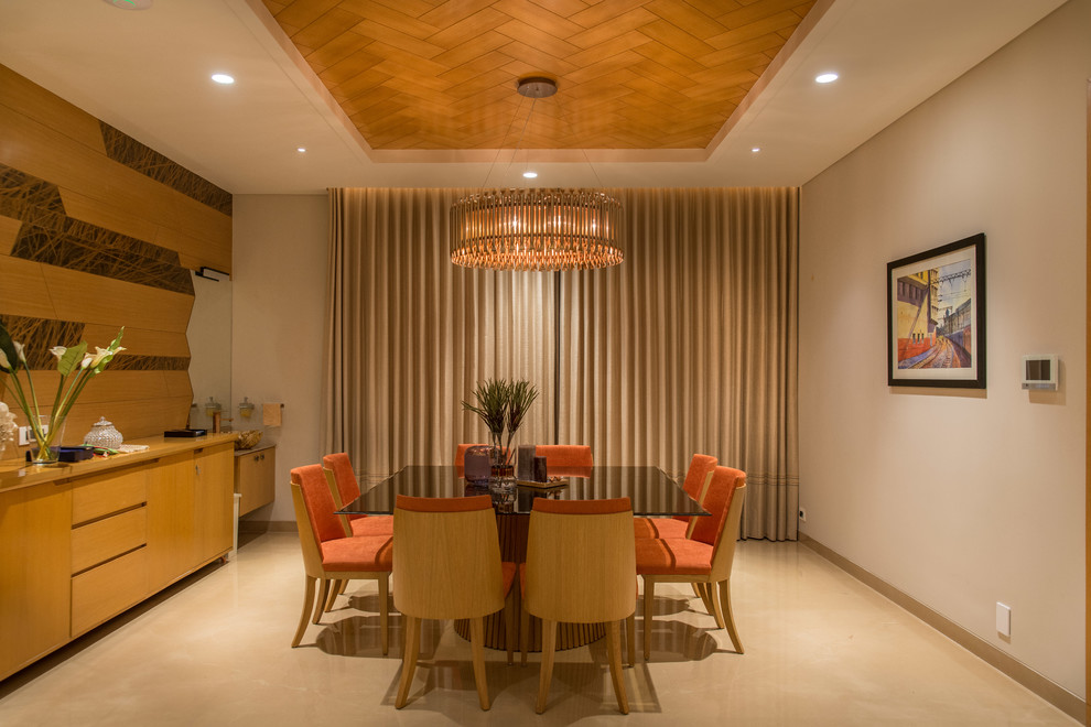 Inspiration for a mid-sized separate dining room in Hyderabad with beige walls and beige floor.