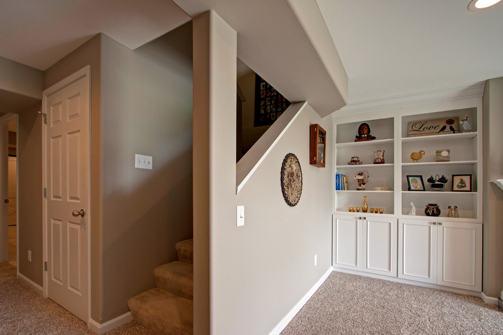 Expansive contemporary walk-out basement in St Louis with beige walls, carpet and a standard fireplace.