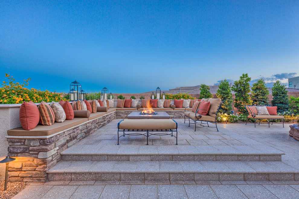 This is an example of a large contemporary backyard patio in Las Vegas with natural stone pavers, no cover and a fire feature.