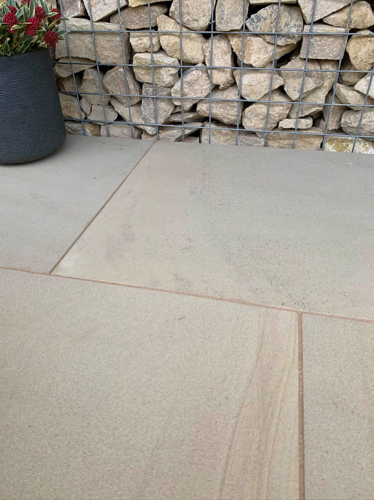 Traditional backyard patio in Hampshire with natural stone pavers.