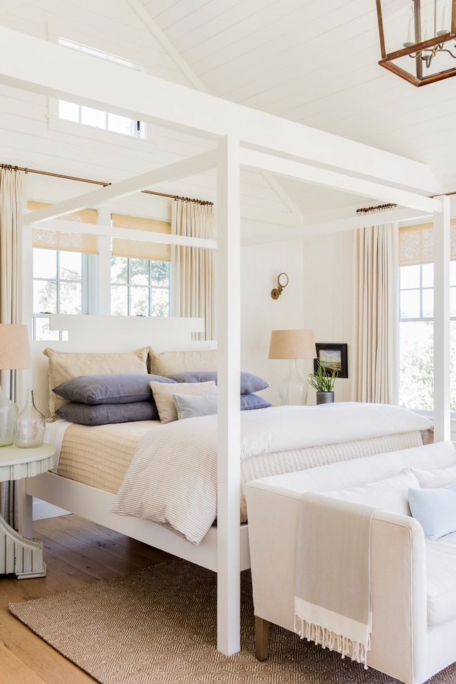 Inspiration for a beach style master bedroom in Boston with white walls, medium hardwood floors and brown floor.