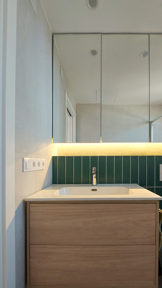 Свежая идея для дизайна: ванная комната среднего размера, в белых тонах с отделкой деревом в стиле модернизм с плоскими фасадами, светлыми деревянными фасадами, инсталляцией, зеленой плиткой, керамической плиткой, зелеными стенами, полом из керамической плитки, монолитной раковиной, серым полом, белой столешницей, зеркалом с подсветкой, тумбой под одну раковину и подвесной тумбой - отличное фото интерьера