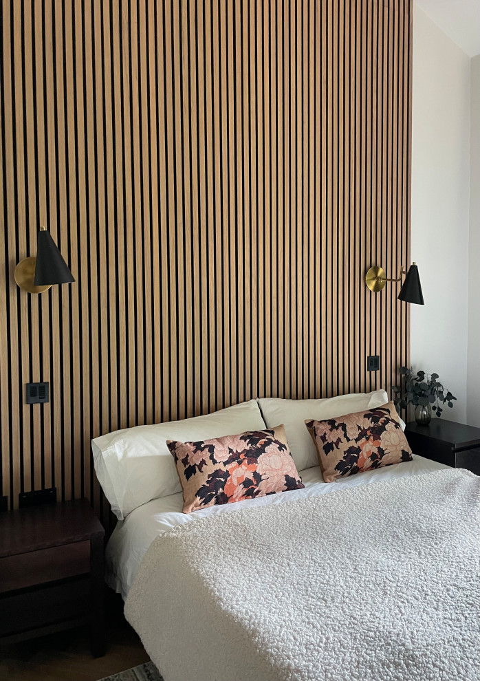 ハートフォードシャーにある中くらいなコンテンポラリースタイルのおしゃれな客用寝室 (グレーの壁、無垢フローリング、茶色い床、三角天井、パネル壁、アクセントウォール) のレイアウト