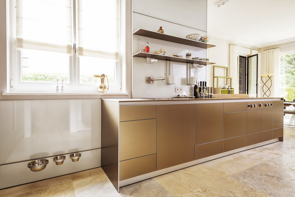 This is an example of a large contemporary u-shaped open plan kitchen in Berlin with an undermount sink, flat-panel cabinets, beige cabinets, limestone benchtops, white splashback, glass sheet splashback, stainless steel appliances, limestone floors, a peninsula, beige floor and brown benchtop.
