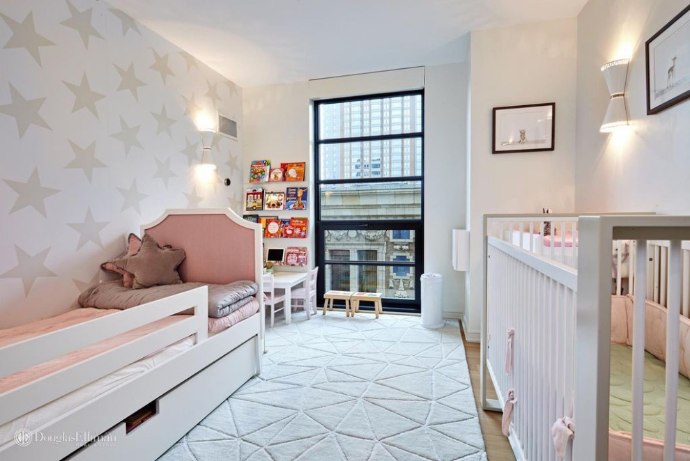 Idee per una cameretta per neonata contemporanea di medie dimensioni con pareti bianche, parquet chiaro, pavimento beige e carta da parati