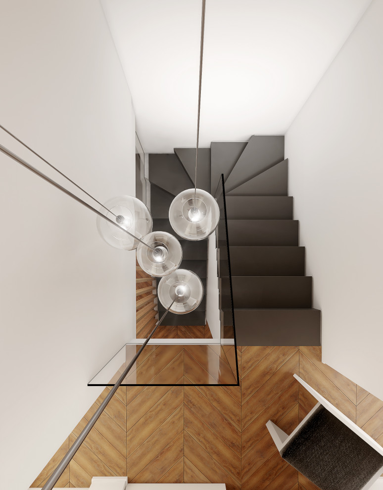 Inspiration for a small contemporary metal u-shaped staircase in Turin with concrete risers and glass railing.