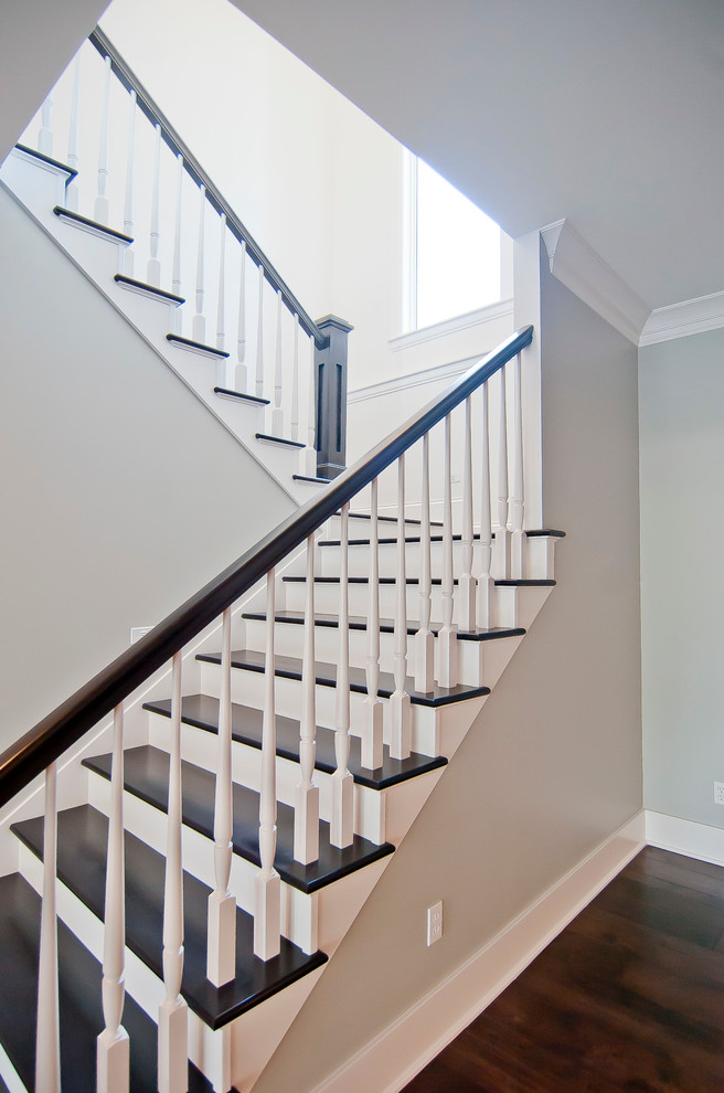 Example of a transitional wooden staircase design with painted risers