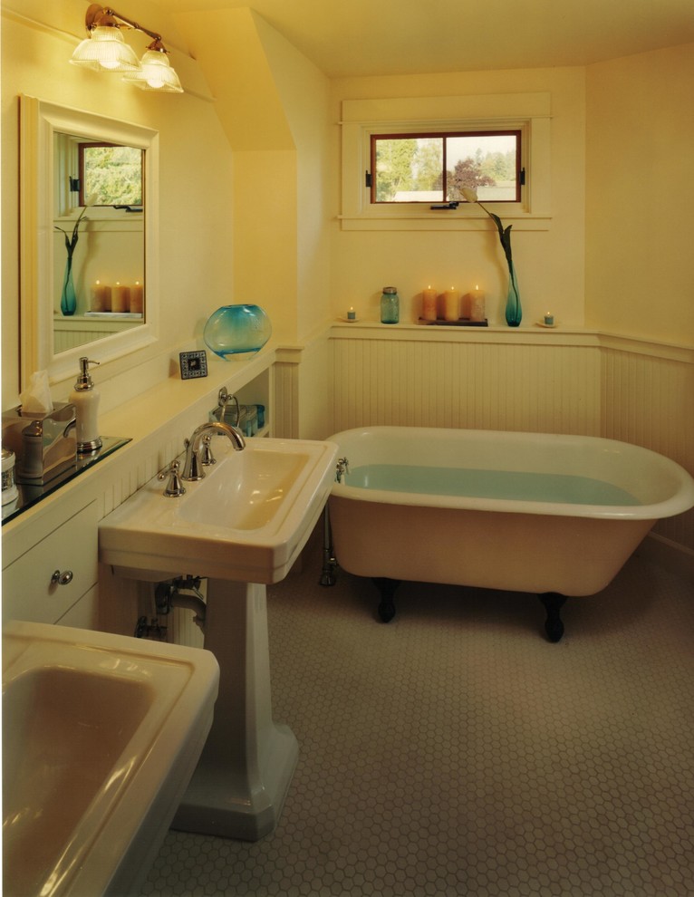 Photo of a mid-sized traditional master bathroom in Seattle with a pedestal sink, beaded inset cabinets, white cabinets, a claw-foot tub, white tile, porcelain tile, porcelain floors, white walls and grey floor.
