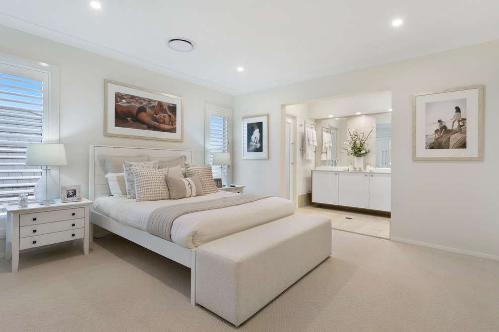 Inspiration for an expansive beach style master bedroom in Sydney with beige walls, carpet, no fireplace and beige floor.