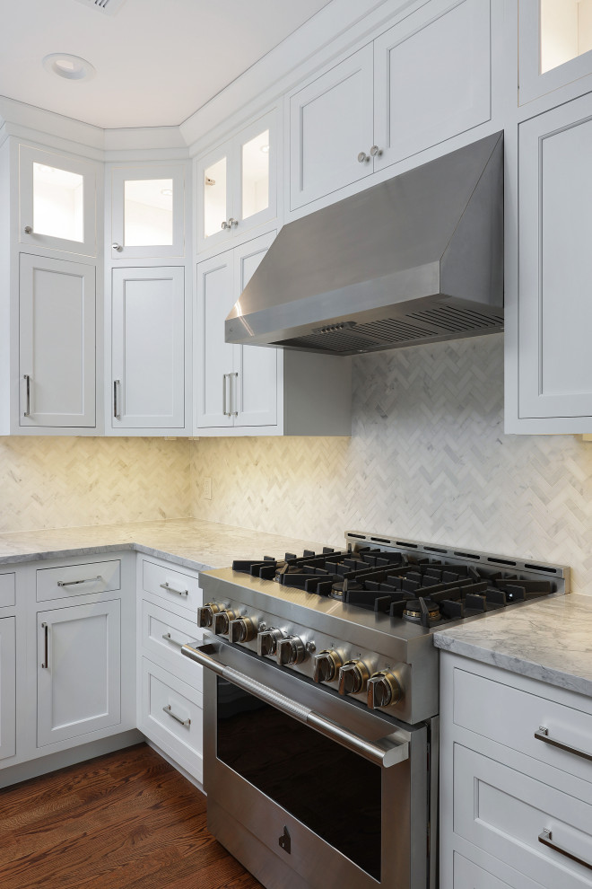 Eat-in kitchen - large transitional u-shaped medium tone wood floor eat-in kitchen idea with shaker cabinets, white cabinets, stainless steel appliances and an island