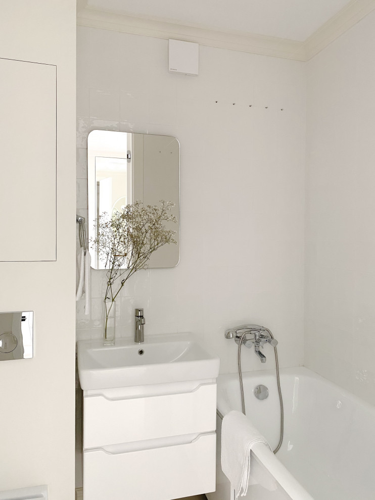 Пример оригинального дизайна: маленькая главная ванная комната в скандинавском стиле с плоскими фасадами, белыми фасадами, инсталляцией, белой плиткой, керамической плиткой, бежевыми стенами, полом из керамогранита, накладной раковиной, бежевым полом, зеркалом с подсветкой, тумбой под одну раковину и подвесной тумбой для на участке и в саду