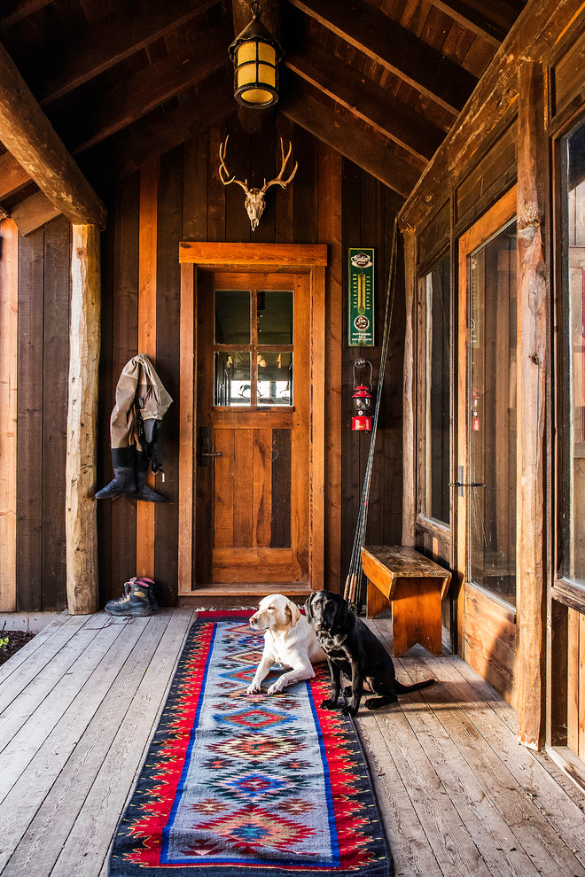 Inspiration for a rustic slate floor and multicolored floor mudroom remodel with a medium wood front door