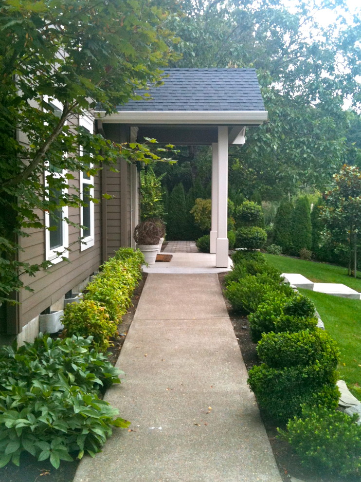 Photo of a large eclectic front yard formal garden in Portland with a container garden and concrete pavers.