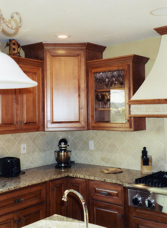 Example of a mid-sized transitional l-shaped kitchen design in Chicago with raised-panel cabinets, medium tone wood cabinets, granite countertops, beige backsplash, cement tile backsplash, stainless steel appliances and an island