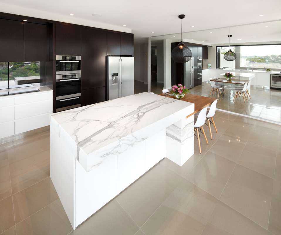This is an example of a mid-sized modern l-shaped separate kitchen in Sydney with an undermount sink, flat-panel cabinets, marble benchtops, metallic splashback, glass sheet splashback, stainless steel appliances, porcelain floors, with island and dark wood cabinets.