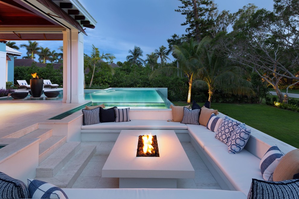 Photo of an expansive tropical backyard patio in Miami with concrete pavers.