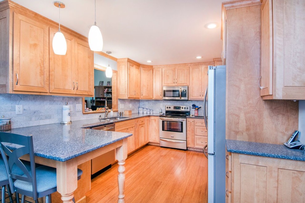 Inspiration for a mid-sized transitional u-shaped bamboo floor and brown floor enclosed kitchen remodel in Cincinnati with a double-bowl sink, shaker cabinets, light wood cabinets, granite countertops, gray backsplash, marble backsplash, stainless steel appliances, a peninsula and gray countertops