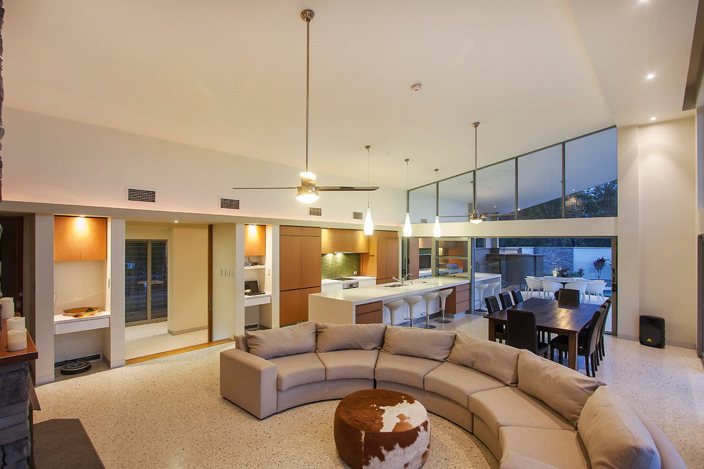 This is an example of a large contemporary open concept living room in Brisbane with white walls, concrete floors, a wood stove and a stone fireplace surround.