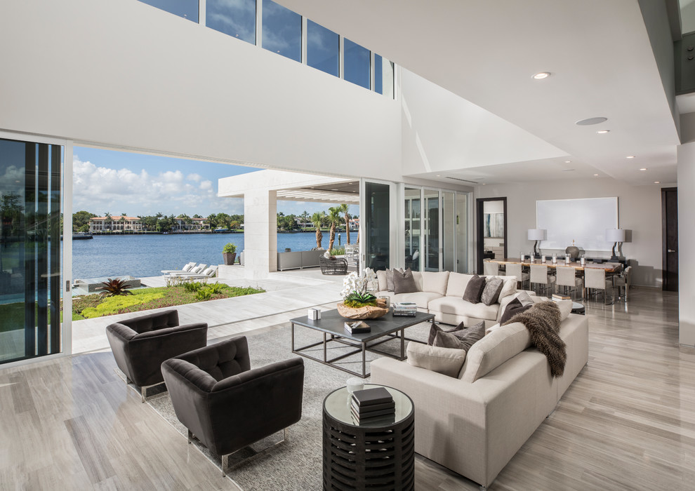 Photo of a contemporary open concept living room in Miami with white walls and grey floor.
