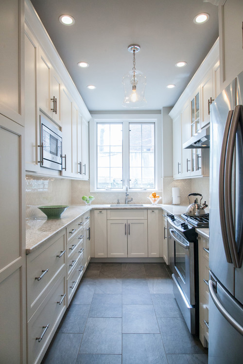 Bright galley kitchen with white Shaker RTA cabinets installed level and plumb—showing tight reveals and aligned wall units as the result of proper assembly and sistering before fastening to studs