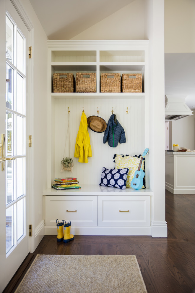 Design ideas for a traditional mudroom in San Francisco with white walls, dark hardwood floors and a glass front door.