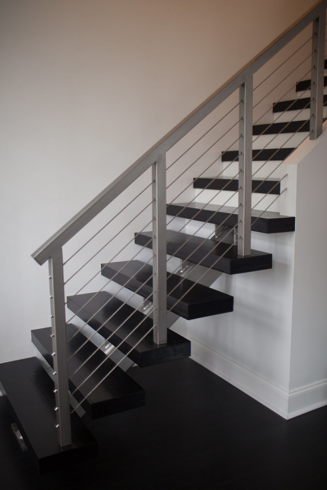 Photo of a mid-sized modern wood straight staircase in Houston with open risers.