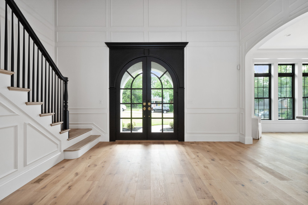 Design ideas for an expansive country front door in St Louis with yellow walls, light hardwood floors, a double front door and a black front door.