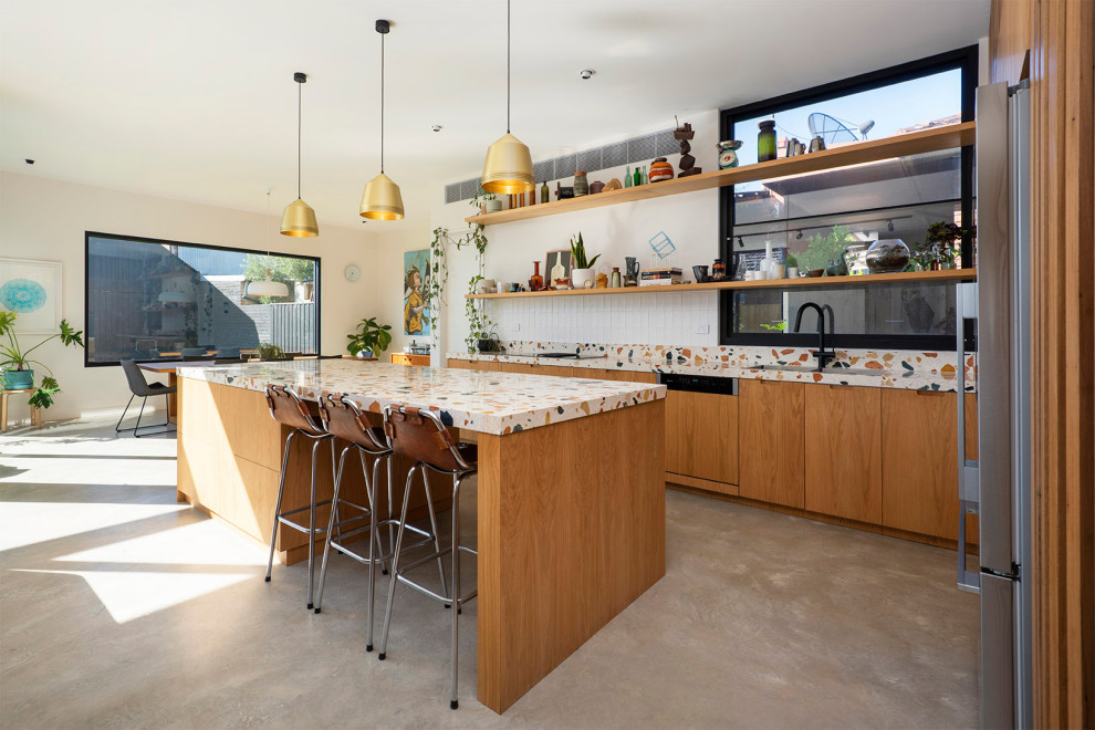 На фото: кухня в стиле фьюжн с двойной мойкой, светлыми деревянными фасадами, столешницей терраццо, белым фартуком, фартуком из керамической плитки, бетонным полом, серым полом и разноцветной столешницей с