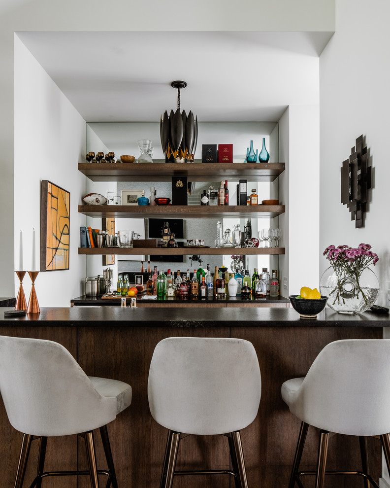 Contemporary galley home bar in Oklahoma City with dark wood cabinets, mirror splashback and black benchtop.