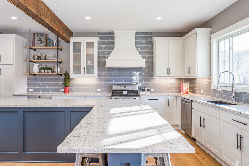 Large transitional l-shaped eat-in kitchen photo with white cabinets, quartzite countertops, gray backsplash, glass tile backsplash, stainless steel appliances and an island