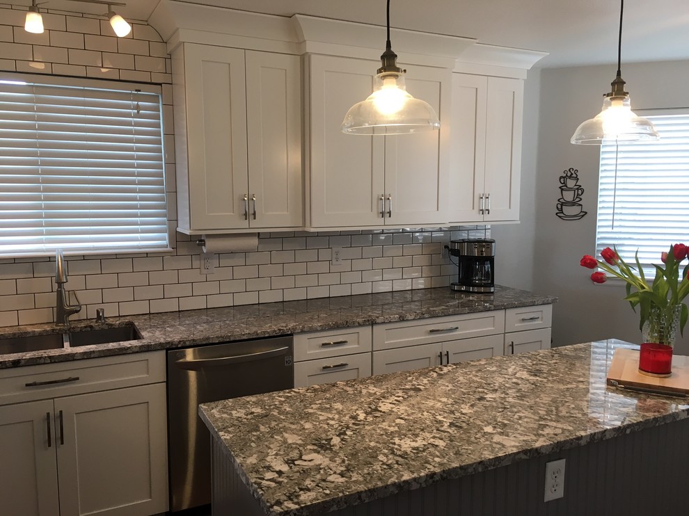 Photo of a mid-sized transitional single-wall eat-in kitchen in Denver with a double-bowl sink, shaker cabinets, white cabinets, granite benchtops, white splashback, subway tile splashback, stainless steel appliances, dark hardwood floors and with island.