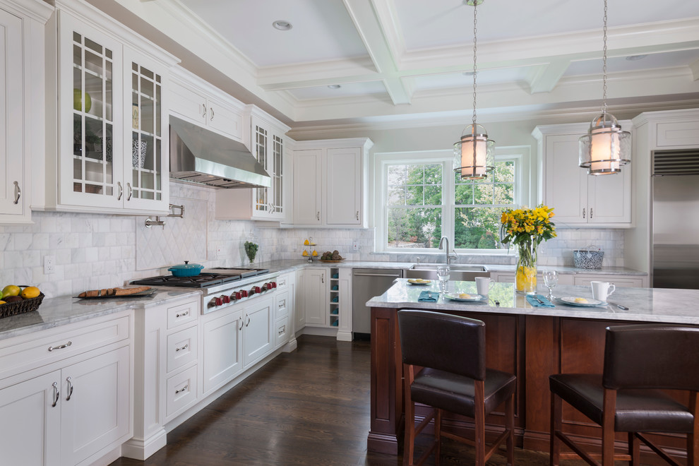 This is an example of a large traditional l-shaped eat-in kitchen in Boston with a farmhouse sink, recessed-panel cabinets, white cabinets, granite benchtops, white splashback, ceramic splashback, stainless steel appliances, dark hardwood floors and with island.