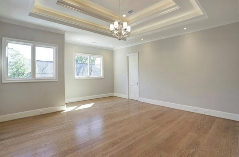 This is an example of a transitional family room in Houston with light hardwood floors, brown floor and recessed.