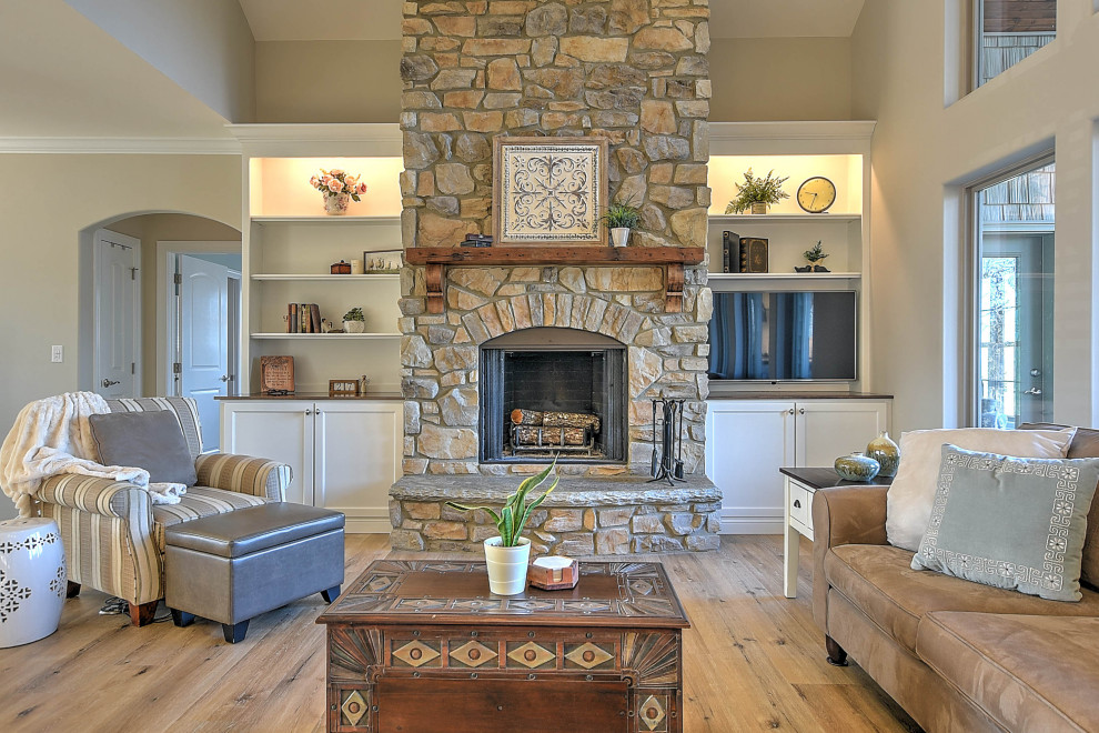 Inspiration for a mid-sized transitional open concept family room in Other with beige walls, vinyl floors, a standard fireplace, a stone fireplace surround, a built-in media wall, beige floor and vaulted.