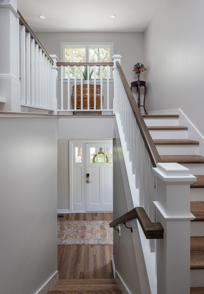 Свежая идея для дизайна: лестница среднего размера в стиле неоклассика (современная классика) с деревянными перилами - отличное фото интерьера