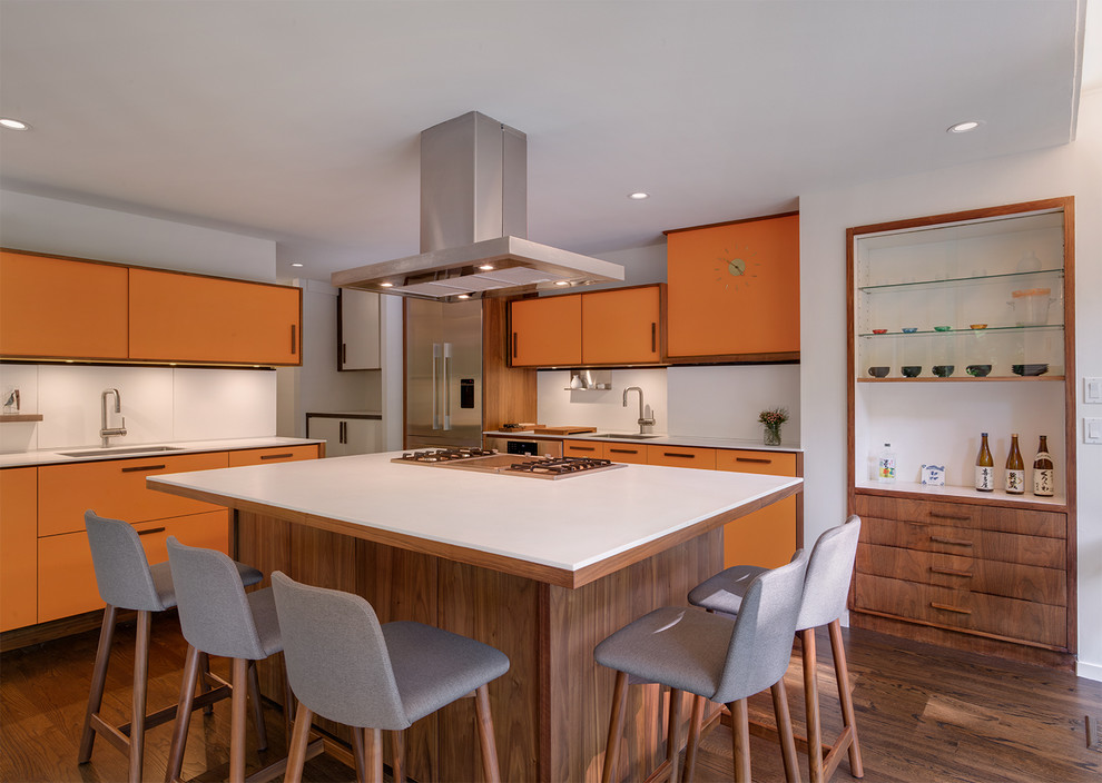 This is an example of a mid-sized midcentury u-shaped open plan kitchen in New York with an undermount sink, flat-panel cabinets, orange cabinets, white splashback, stainless steel appliances, dark hardwood floors, with island and quartz benchtops.