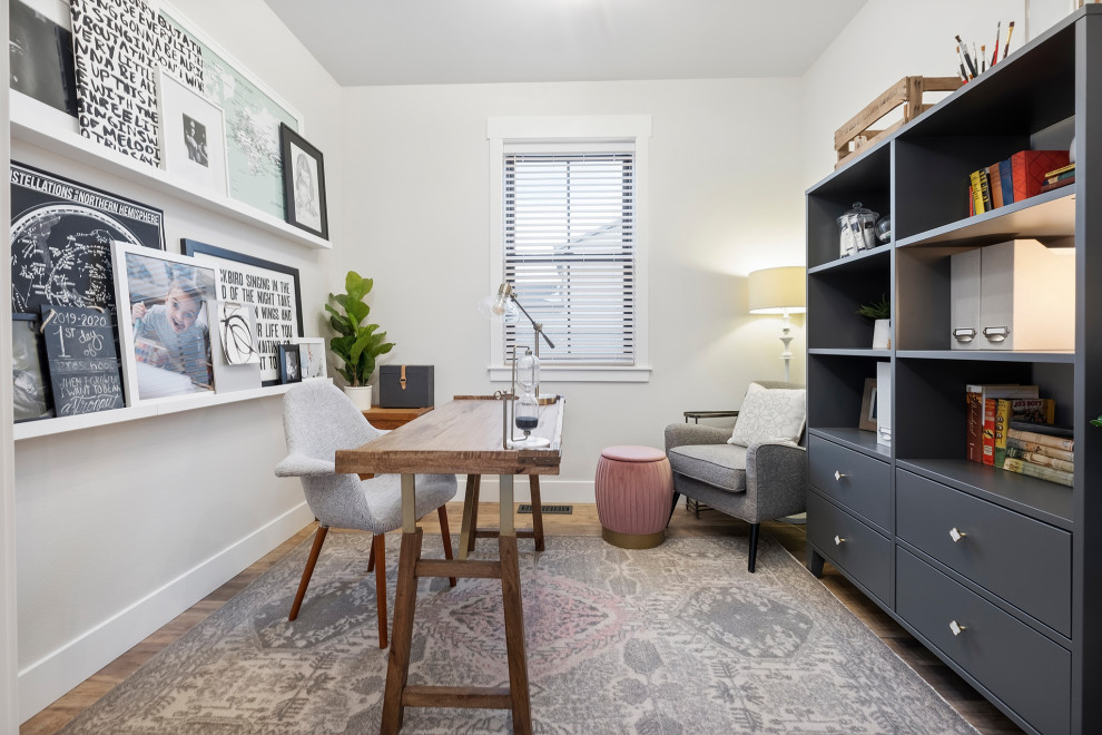 This is an example of a transitional home office in Other with white walls, a freestanding desk and brown floor.