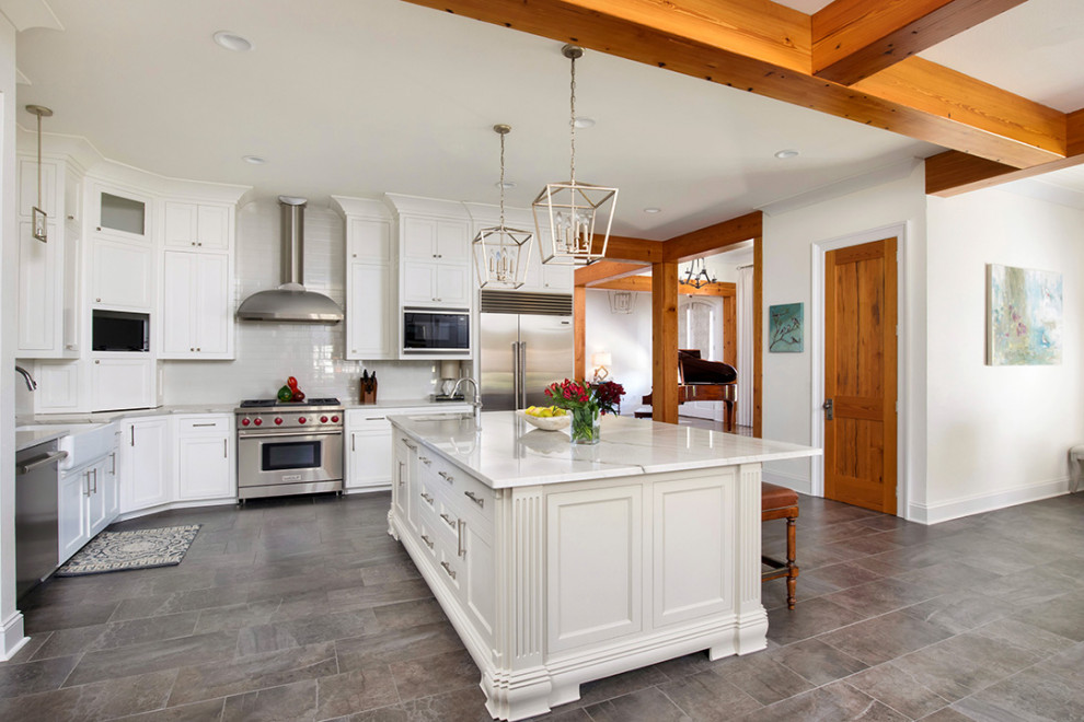 Eat-in kitchen - mid-sized transitional l-shaped porcelain tile, gray floor and exposed beam eat-in kitchen idea in New Orleans with a farmhouse sink, recessed-panel cabinets, white cabinets, quartzite countertops, gray backsplash, ceramic backsplash, stainless steel appliances, an island and white countertops