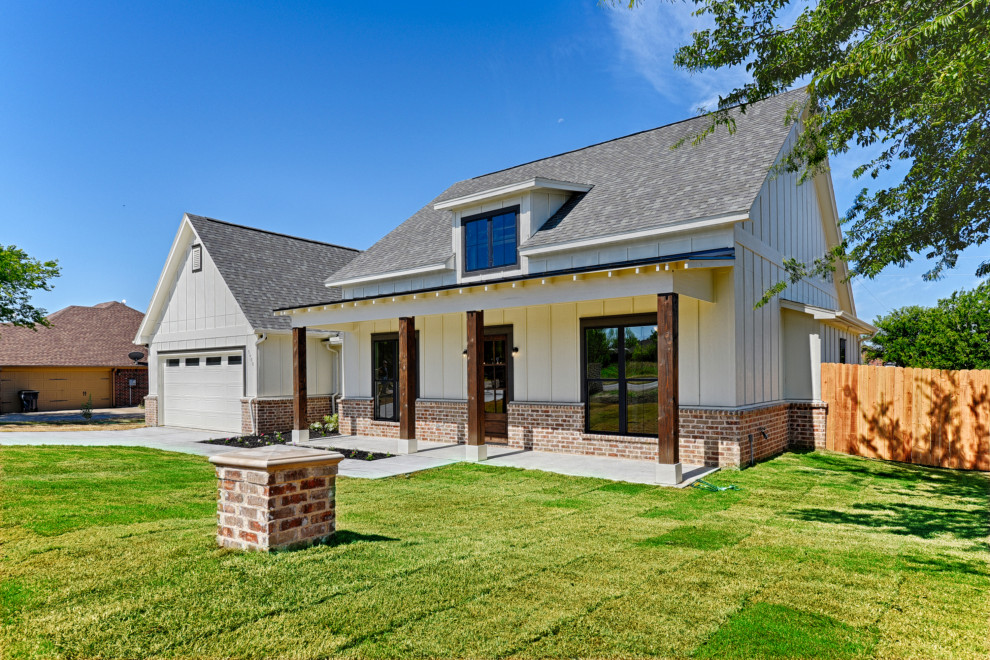 Einstöckiges Landhaus Einfamilienhaus mit Faserzement-Fassade, weißer Fassadenfarbe, Satteldach, Schindeldach und Wandpaneelen in Dallas