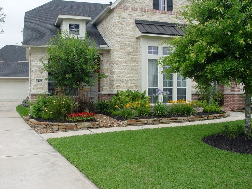 Photo of a mid-sized traditional front yard partial sun garden in Houston with a container garden and concrete pavers.