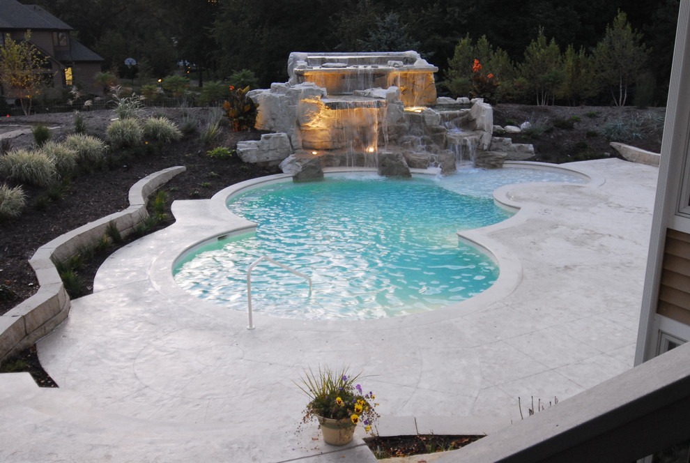 Inspiration for a mid-sized beach style backyard custom-shaped natural pool in Chicago with a water feature and stamped concrete.