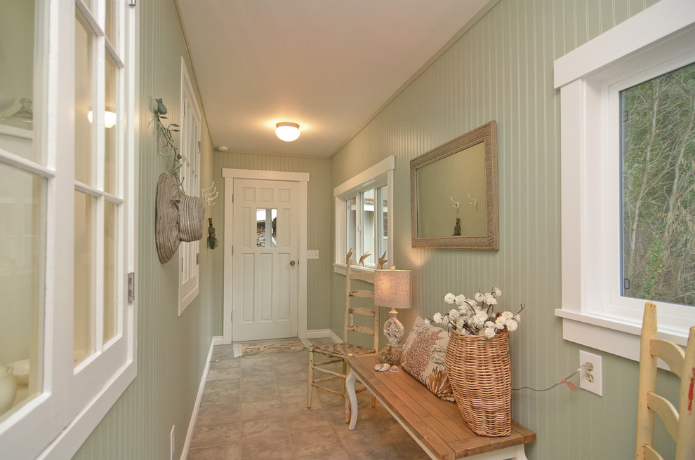 Beach style entry hall in Seattle with porcelain floors, green walls, a single front door, a white front door and beige floor.