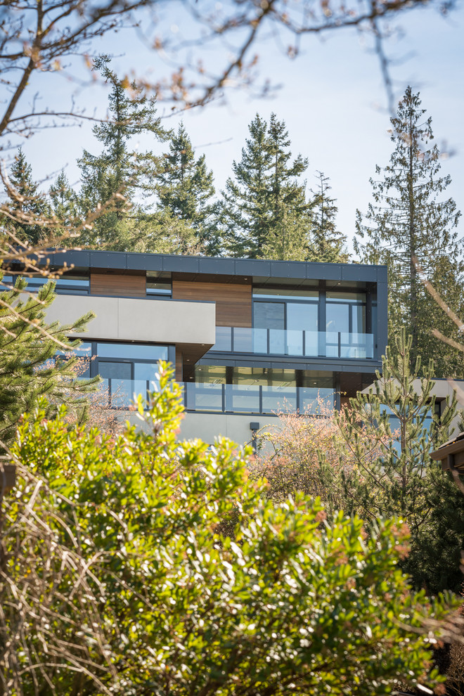 This is an example of a large contemporary three-storey stucco black exterior in Seattle with a flat roof.