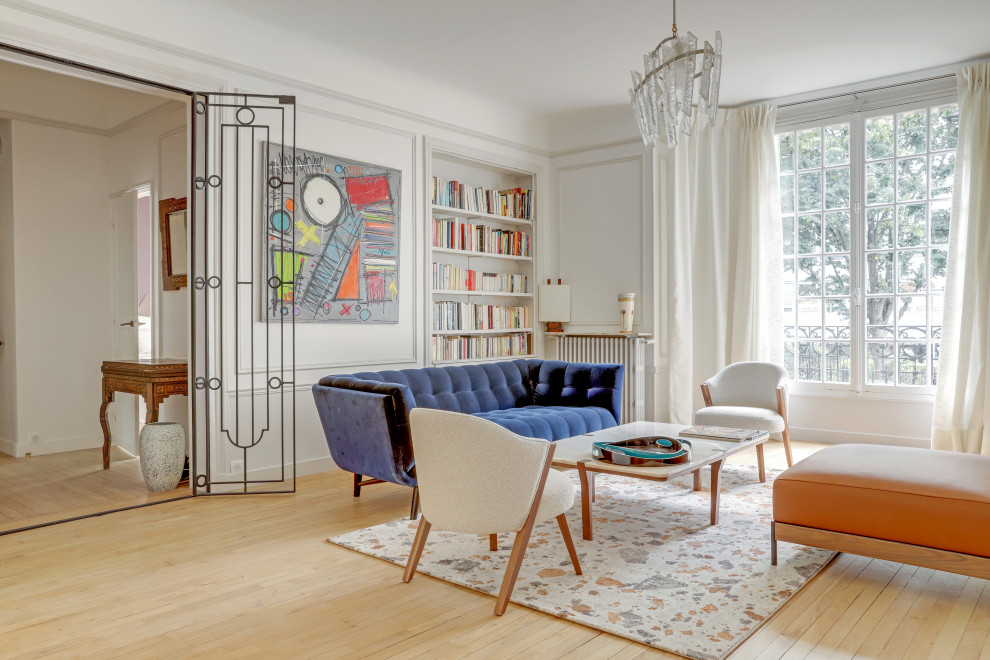This is an example of a contemporary living room in Paris with white walls, light hardwood floors, beige floor and panelled walls.