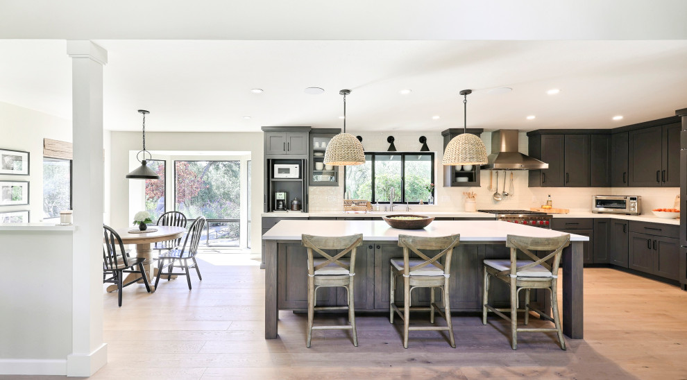 Inspiration for a mid-sized transitional l-shaped laminate floor open concept kitchen remodel with a double-bowl sink, flat-panel cabinets, gray cabinets, quartz countertops, white backsplash, ceramic backsplash, stainless steel appliances, an island and white countertops