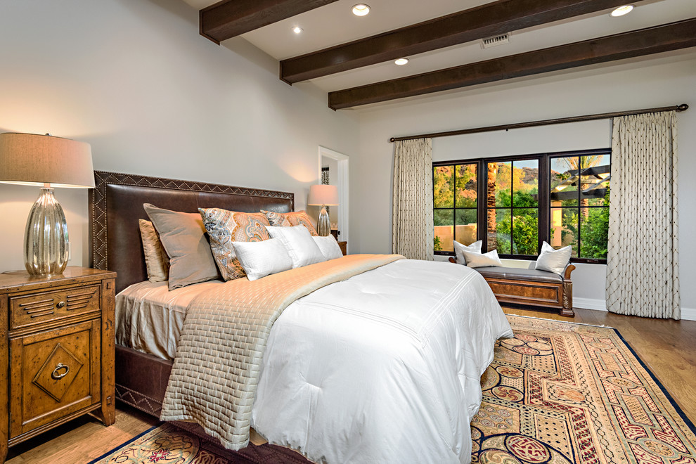 Design ideas for a mediterranean master bedroom in Phoenix with no fireplace, grey walls and medium hardwood floors.